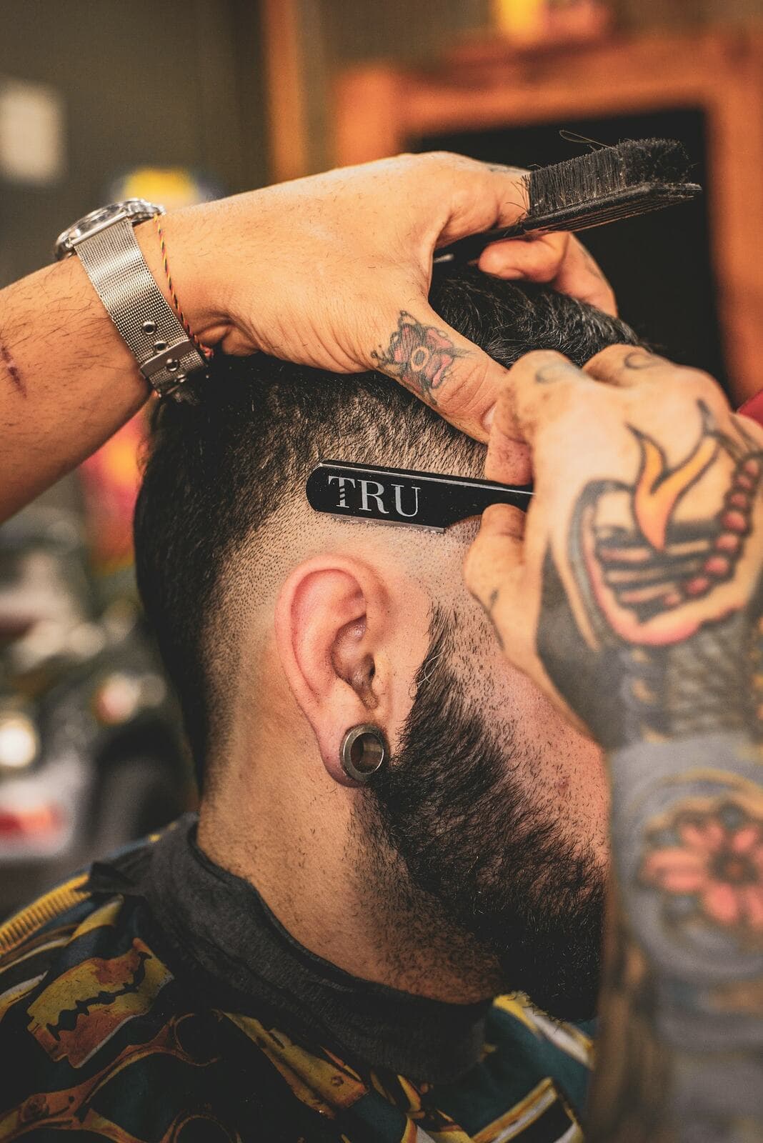 Handen die met schaar en kam het haar in model knippen bij Kapsalon Basel